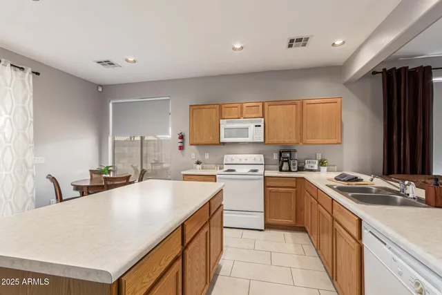 a kitchen with a stove a sink a refrigerator and cabinets