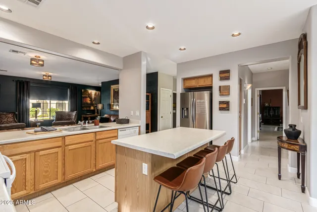 a kitchen with a dining table chairs and refrigerator