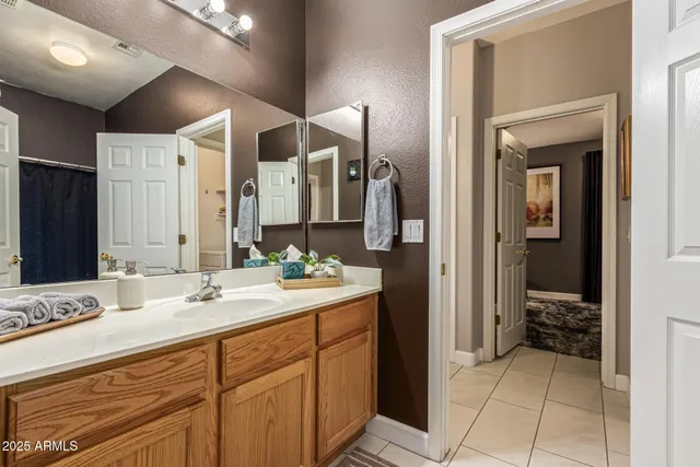 a bathroom with double vanity and a mirror