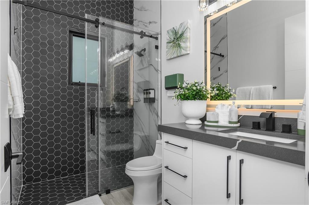 1347 23rd Street Southwest Naples, FL 34117 - Photo 15 of 50 a bathroom with a granite countertop sink a toilet and shower