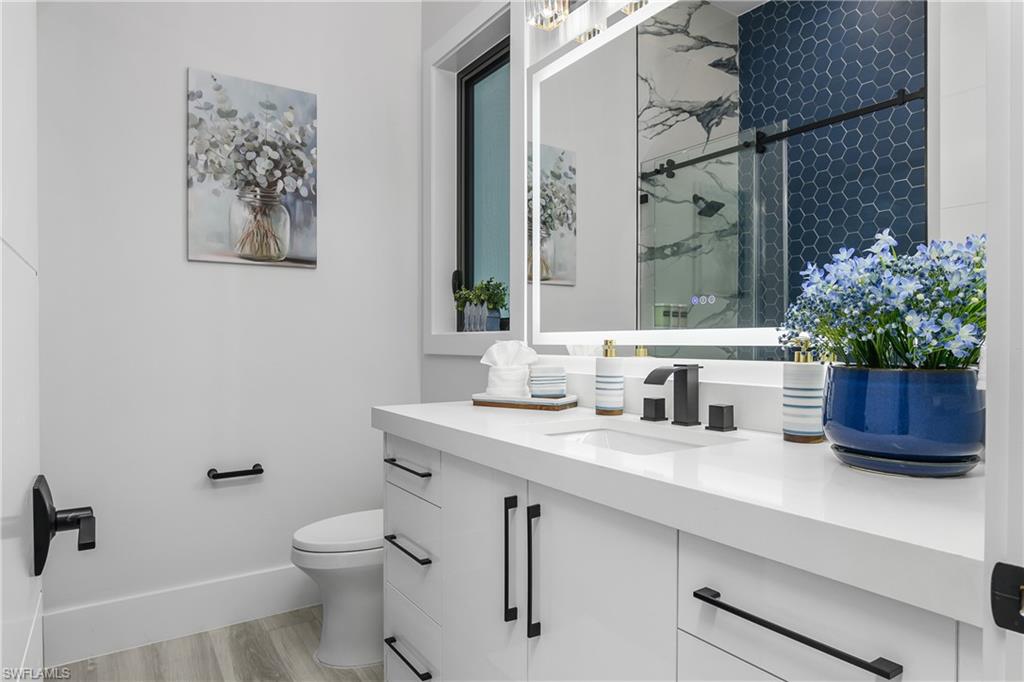 1347 23rd Street Southwest Naples, FL 34117 - Photo 17 of 50 a bathroom with a sink a toilet and a mirror