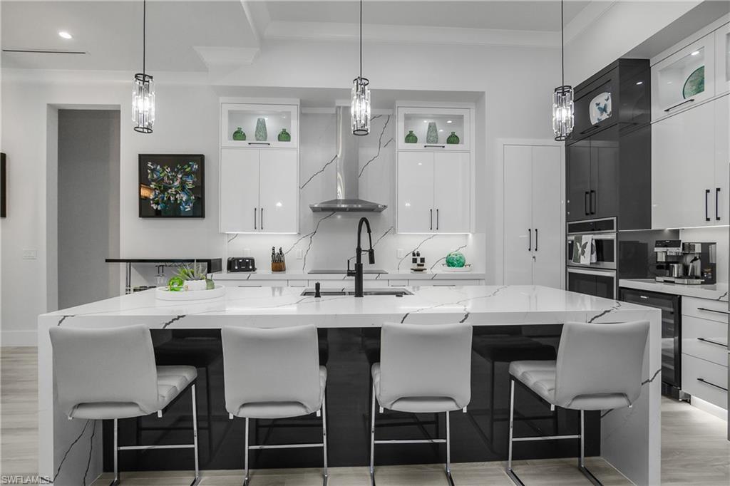 1347 23rd Street Southwest Naples, FL 34117 - Photo 25 of 50 a white kitchen with a dining table and chairs