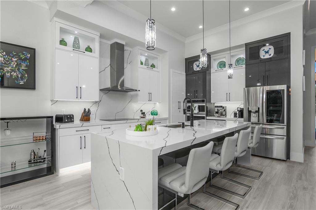 1347 23rd Street Southwest Naples, FL 34117 - Photo 26 of 50 a kitchen with white cabinets and stainless steel appliances