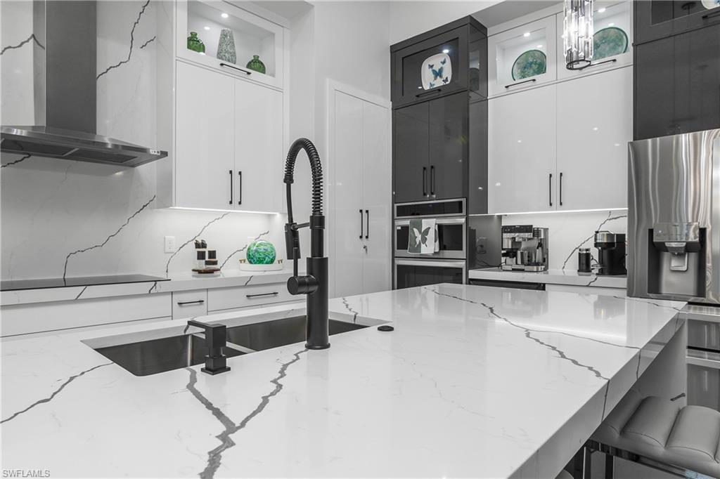 1347 23rd Street Southwest Naples, FL 34117 - Photo 28 of 50 a kitchen with stainless steel appliances a stove a sink and a refrigerator