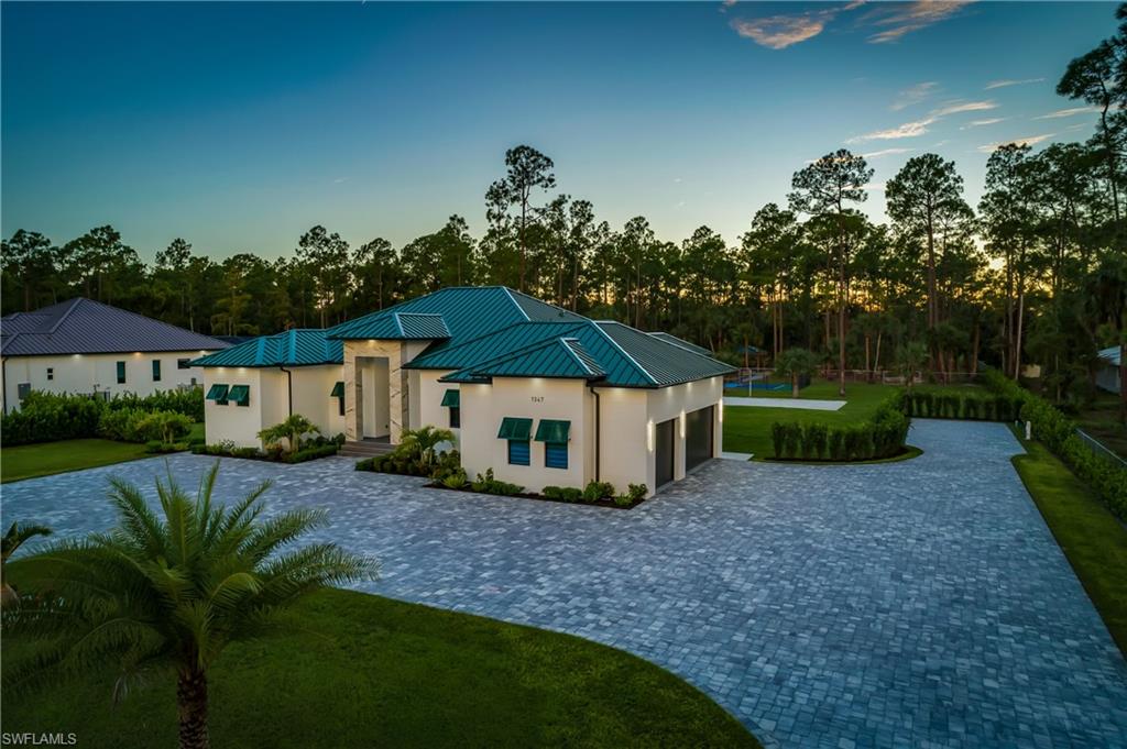 1347 23rd Street Southwest Naples, FL 34117 - Photo 3 of 50 a view of a house with a yard and potted plants