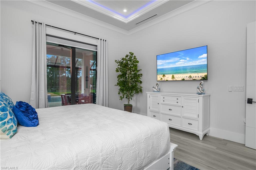 1347 23rd Street Southwest Naples, FL 34117 - Photo 7 of 50 a bedroom with a bed and a flat screen tv