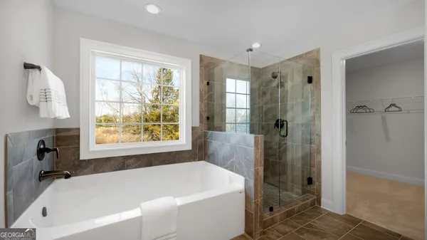 a white bath tub sitting in a bathroom next to a window