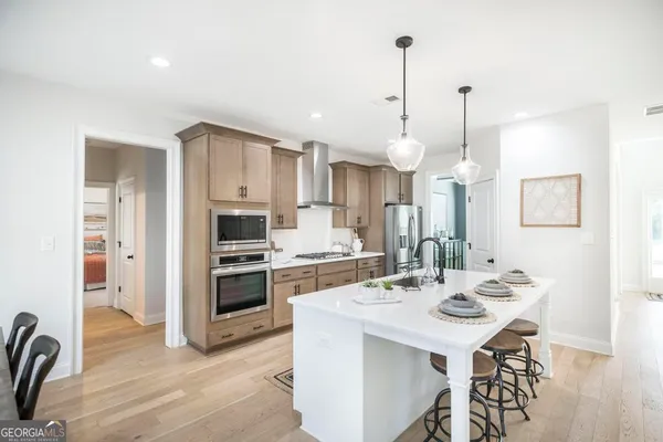 a kitchen with a sink a stove a refrigerator cabinets and wooden floor