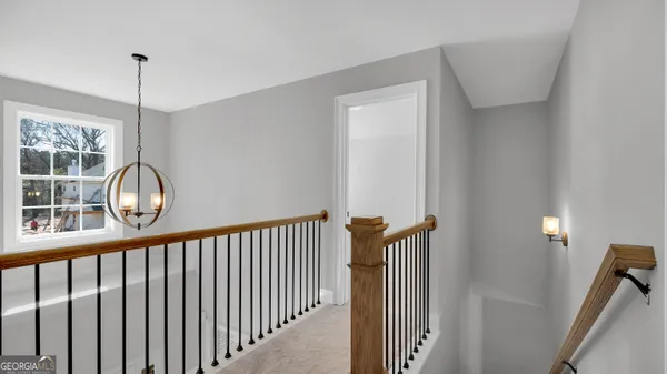 a view of a hallway with wooden floor and a window