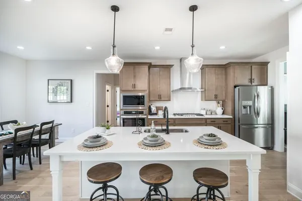 a kitchen with refrigerator cabinets dining table and chairs