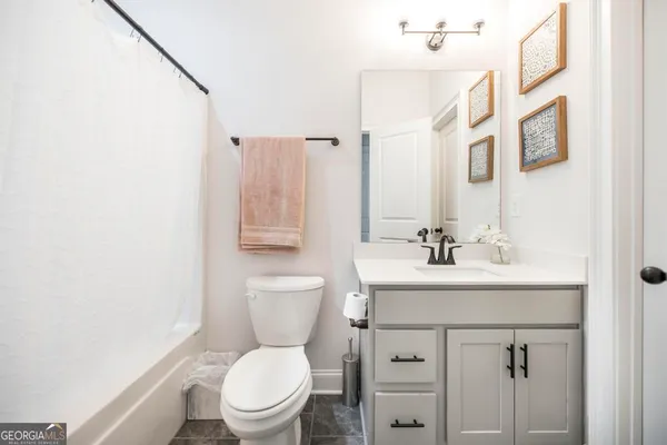 a bathroom with a toilet sink vanity and mirror