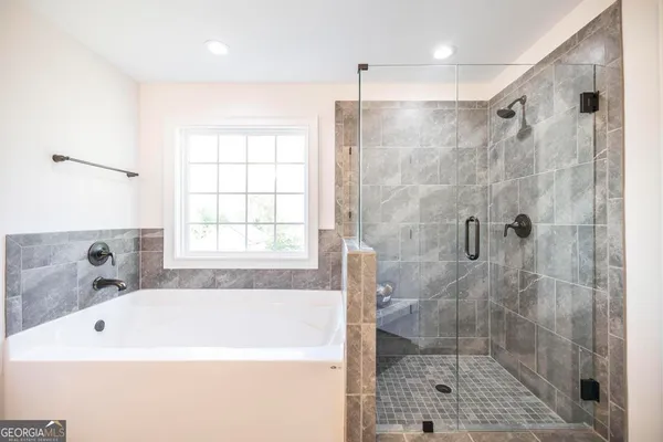 a bathroom with a bathtub a shower and a sink