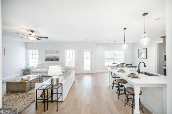 a view of a dining room and livingroom with furniture wooden floor a chandelier