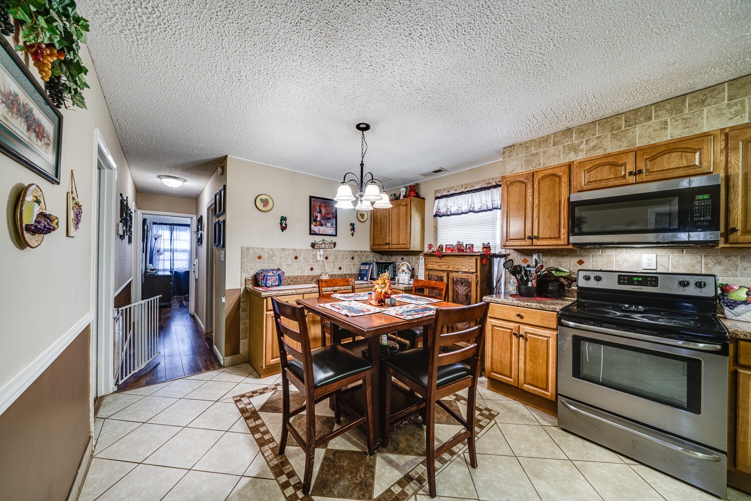 2757 Dale Ridge Road Dowelltown, TN 37059 - Photo 18 of 28 a kitchen with stainless steel appliances granite countertop a stove top oven a sink dishwasher a dining table and chairs with wooden floor