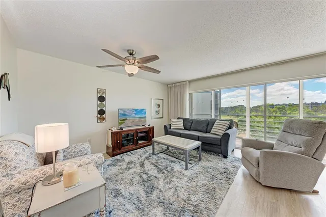 a living room with furniture and a large window with wooden floor
