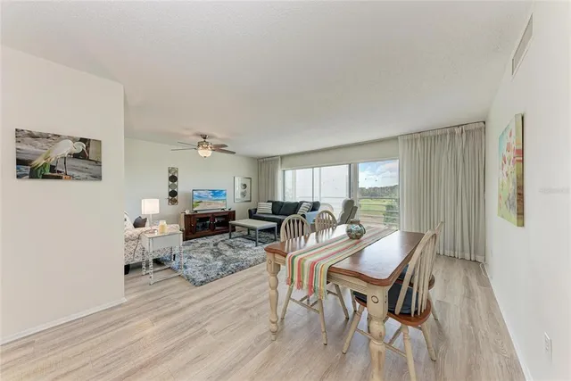 a living room with furniture a wooden floor and a large window
