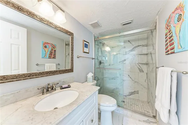 a bathroom with a granite countertop sink toilet a mirror a shower and a bathtub