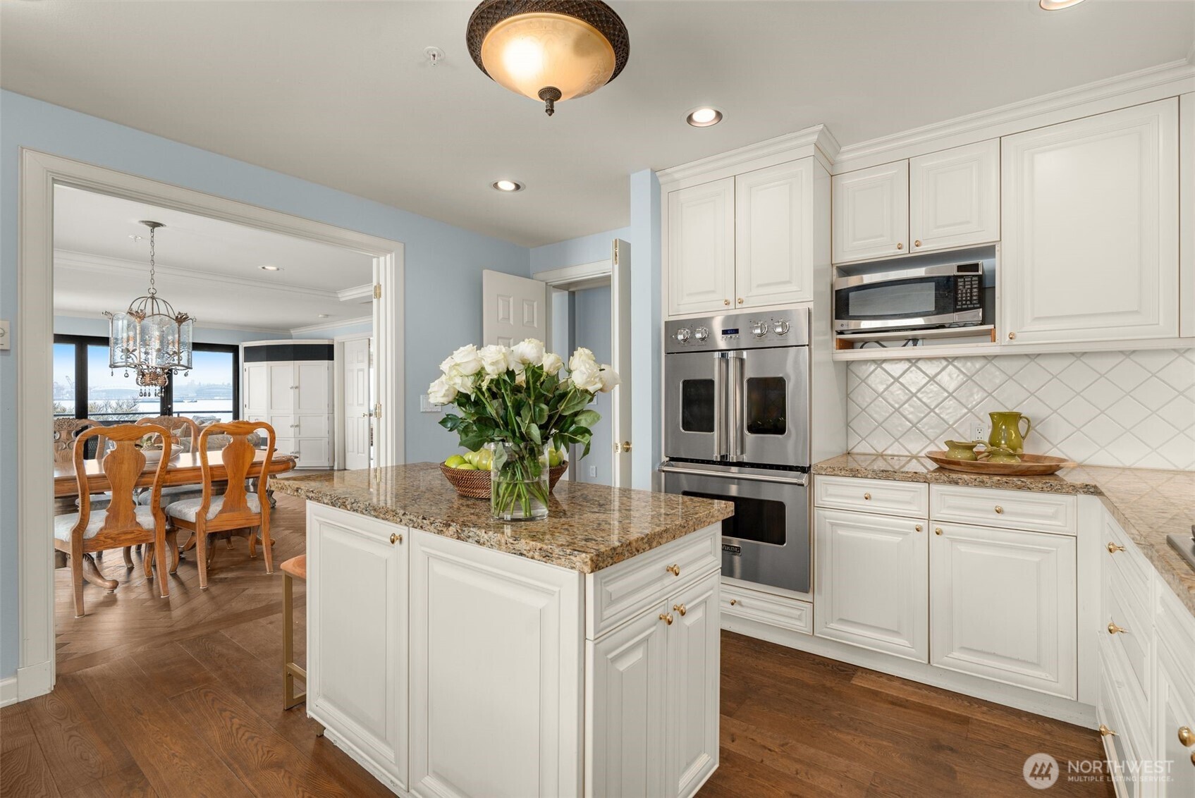 1333 Harbor Avenue Southwest, Unit 204 Seattle, WA 98116 - Photo 13 of 27 a kitchen with stainless steel appliances kitchen island granite countertop a stove and white cabinets