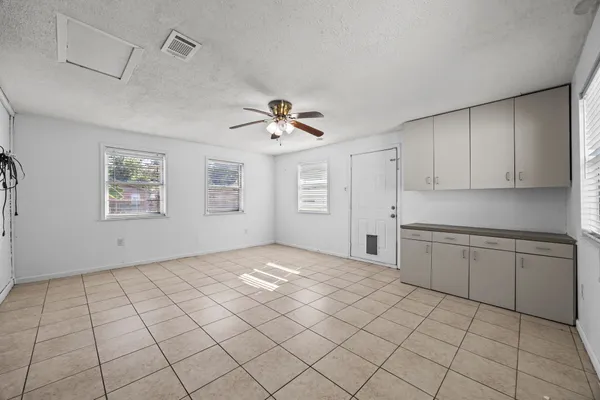 a view of an empty room with window and cabinet