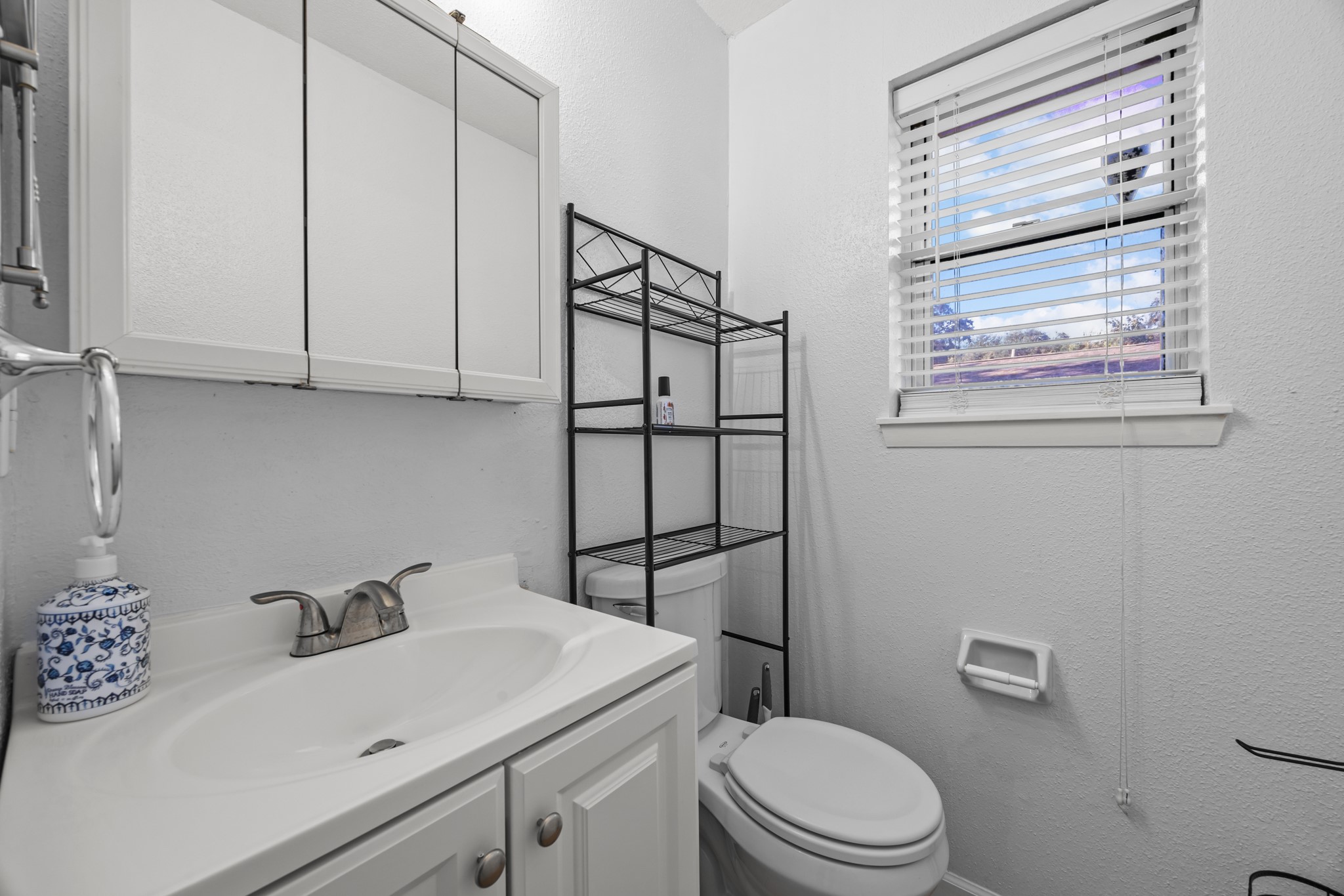 2103 6th Street Stafford, TX 77477 - Photo 16 of 27 a bathroom with a sink a toilet and vanity