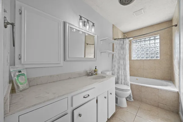 a bathroom with a granite countertop toilet a sink and bathtub