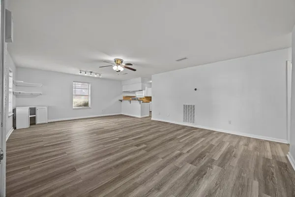 a view of a livingroom with wooden floor and window