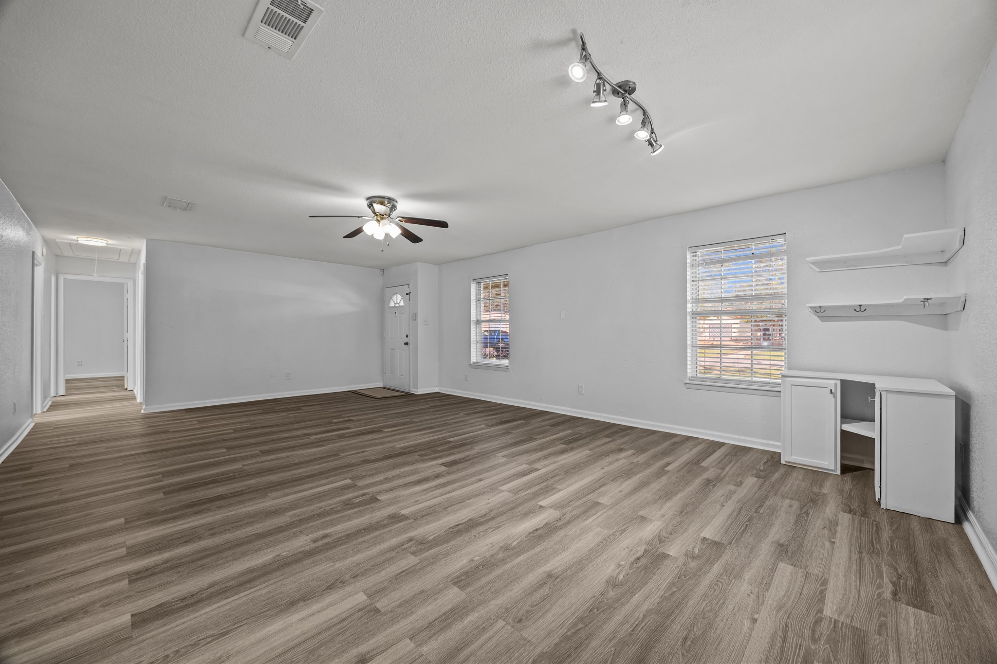 2103 6th Street Stafford, TX 77477 - Photo 5 of 27 an empty room with wooden floor chandelier fan and windows