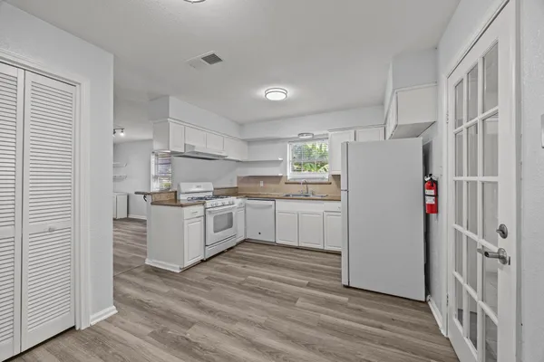 a kitchen with white cabinets and white appliances
