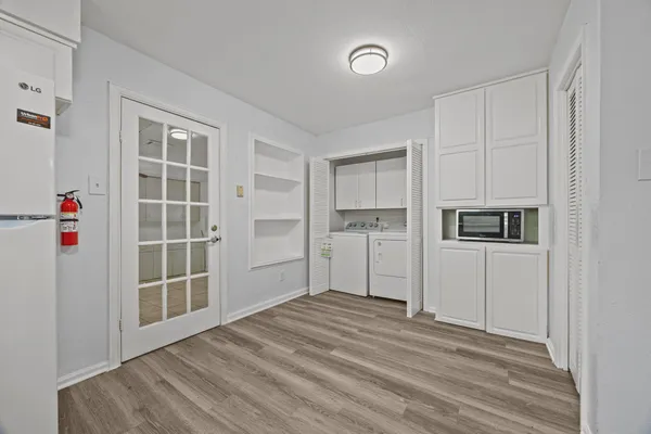 a view of empty room with a kitchen and a window