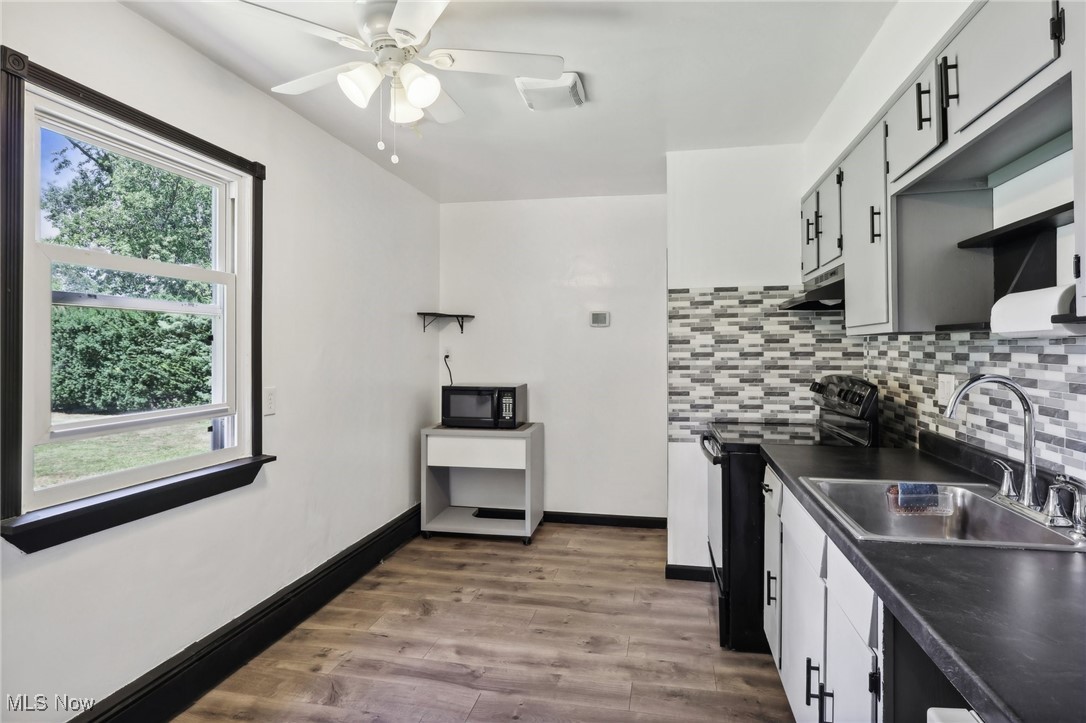 1829 Clyde Road Madison, OH 44057 - Photo 18 of 40 Kitchen featuring black appliances, sink, hardwood / wood-style flooring, and plenty of natural light