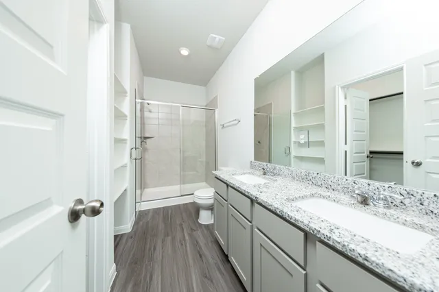 a bathroom with a granite countertop sink a mirror and a shower