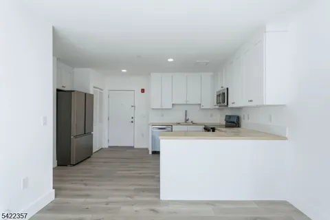 a kitchen with a refrigerator sink and cabinets