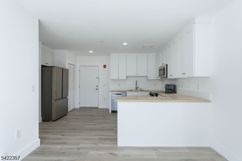 95 Shepherd Lane, Unit B307 Totowa, NJ 07512 - Photo 2 of 13 a kitchen with a refrigerator sink and cabinets