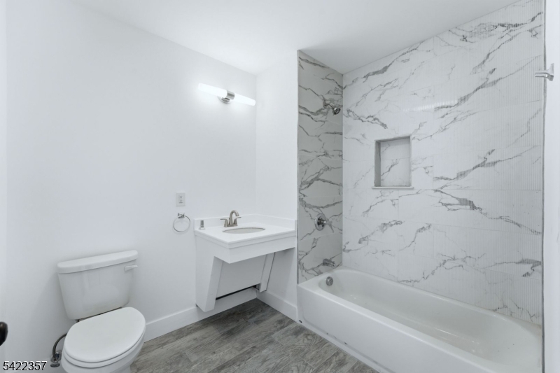 95 Shepherd Lane, Unit B307 Totowa, NJ 07512 - Photo 9 of 13 a bathroom with a sink a toilet and shower