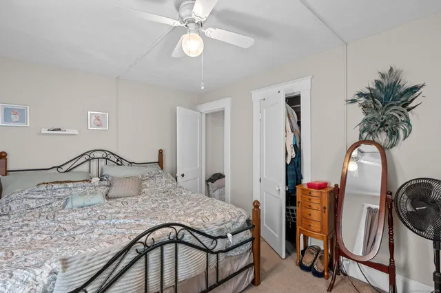 a bedroom with a bed a chandelier and dresser