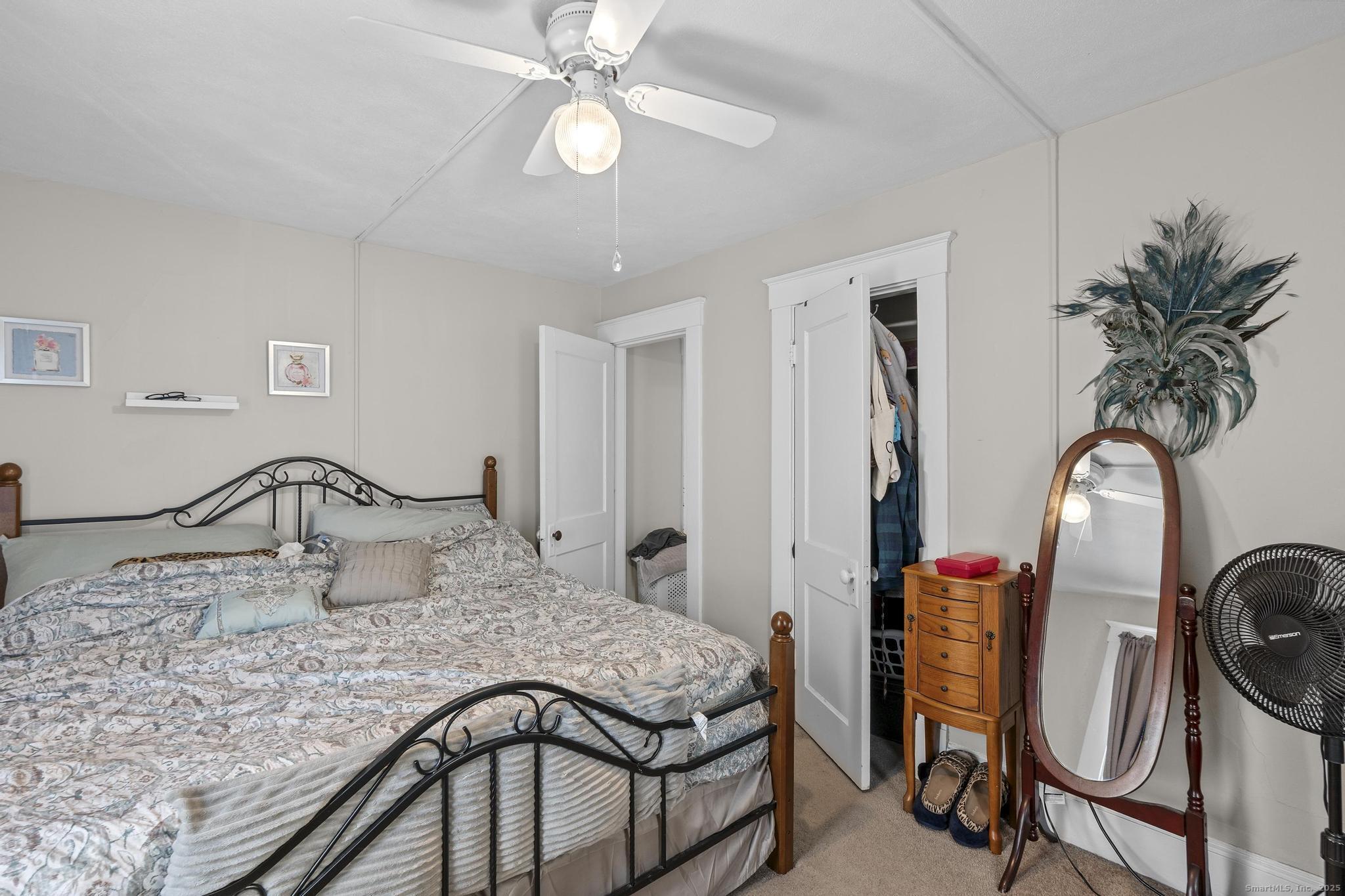 86 Windsor Street Enfield, CT 06082 - Photo 19 of 35 a bedroom with a bed a chandelier and dresser