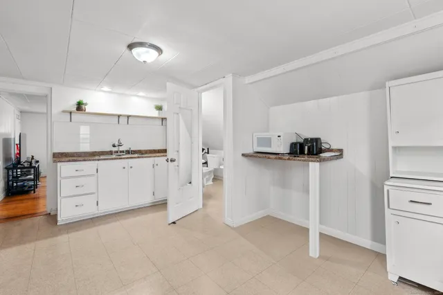 a kitchen with white cabinets and refrigerator
