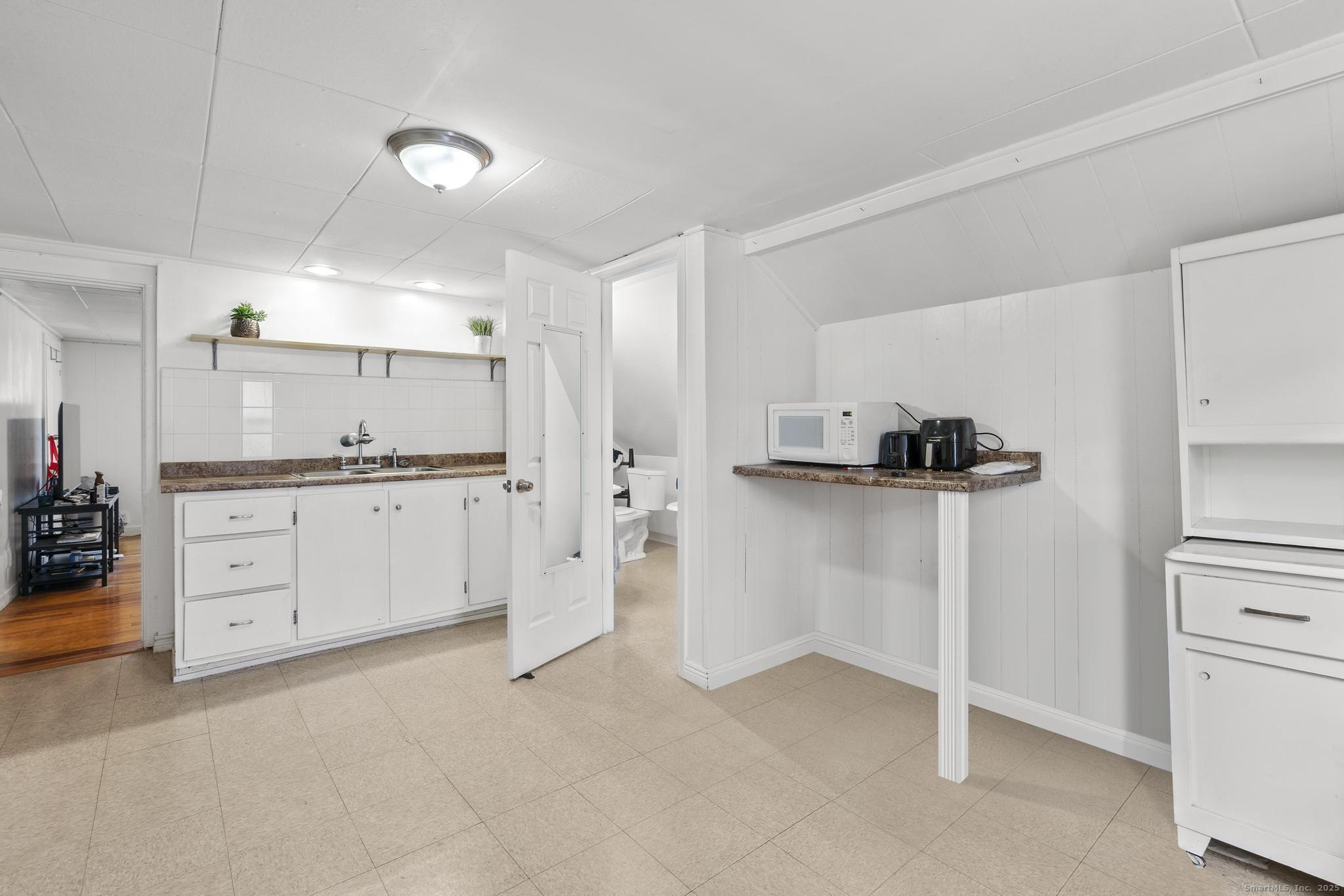 86 Windsor Street Enfield, CT 06082 - Photo 25 of 35 a kitchen with white cabinets and refrigerator