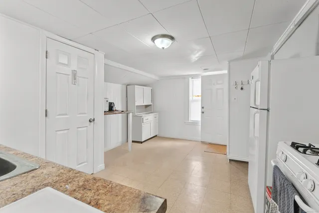 a view of a kitchen with white cabinets and wooden floor
