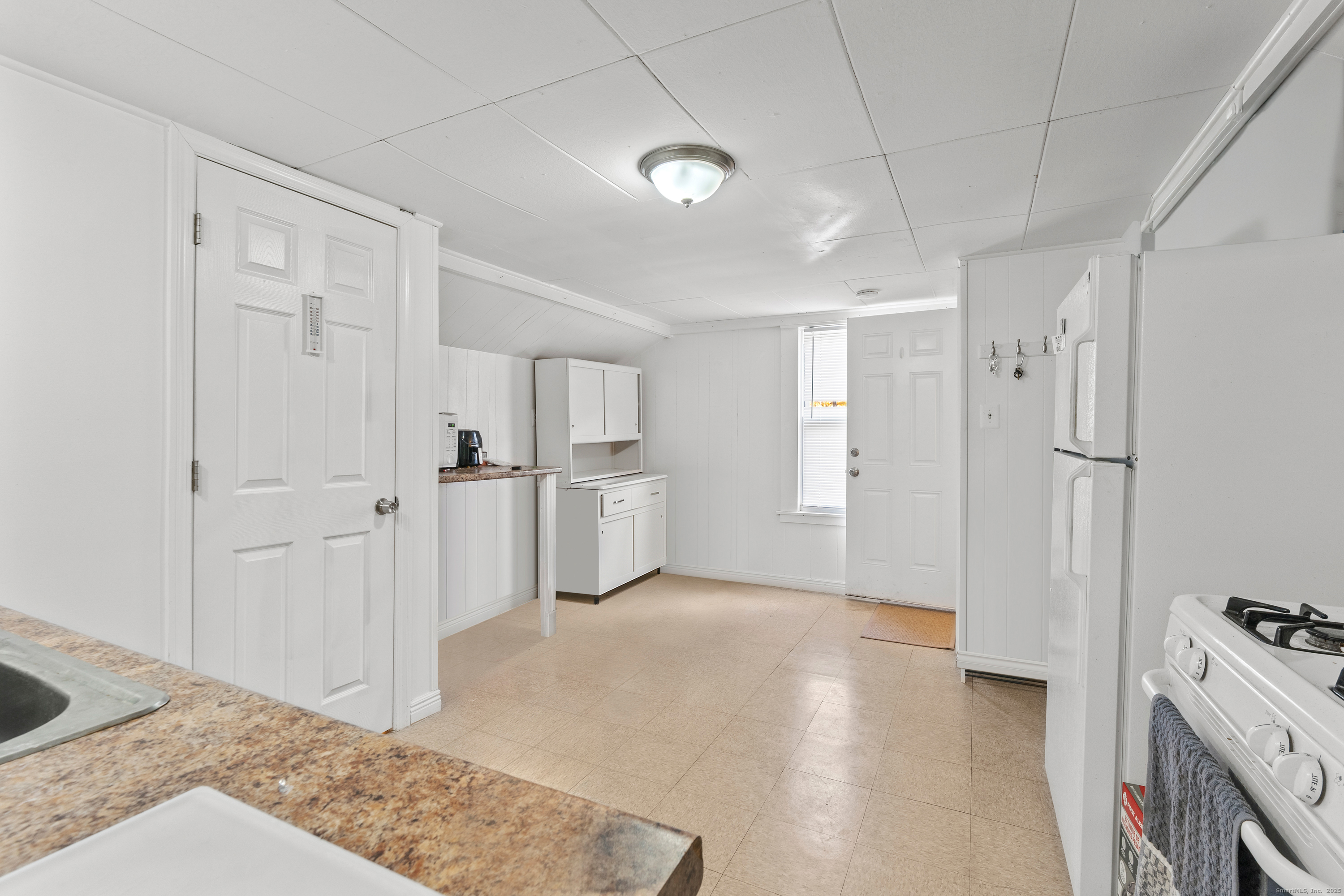 86 Windsor Street Enfield, CT 06082 - Photo 27 of 35 a view of a kitchen with white cabinets and wooden floor
