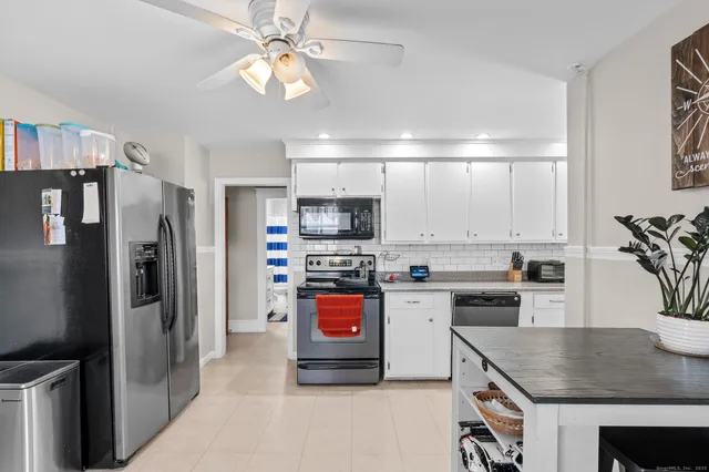 a kitchen with stainless steel appliances granite countertop a refrigerator stove microwave and sink