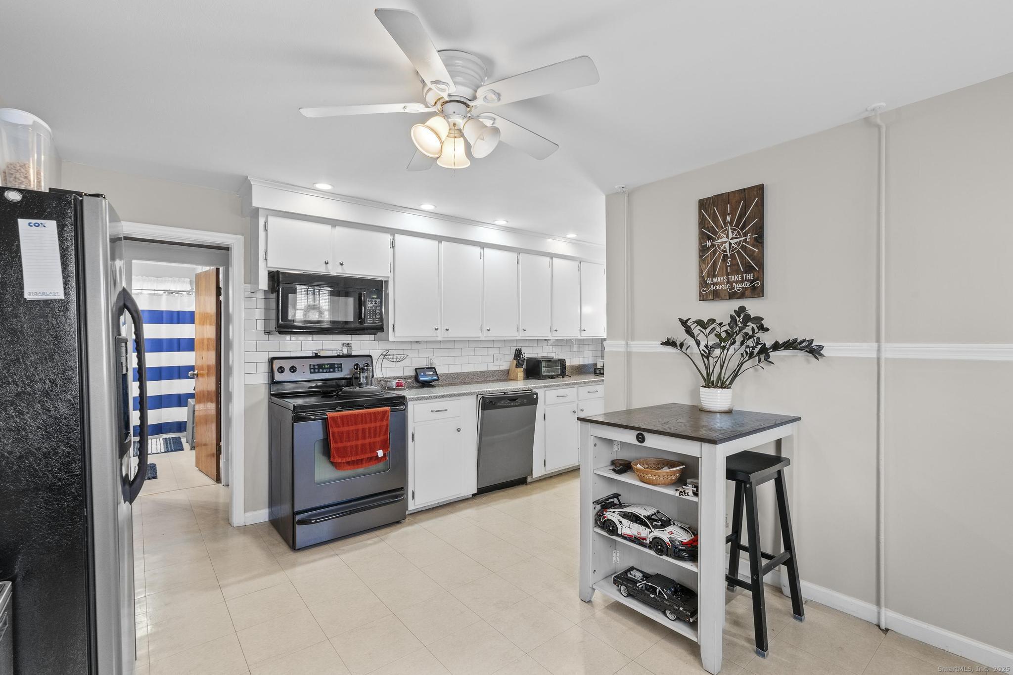 86 Windsor Street Enfield, CT 06082 - Photo 5 of 35 a kitchen with stainless steel appliances a stove a sink and a refrigerator