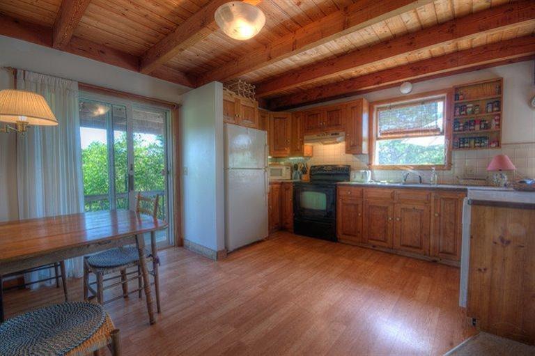 22 Knowles Heights Road Truro, MA 02666 - Photo 8 of 25 a kitchen with stainless steel appliances granite countertop wooden floors and wooden cabinets