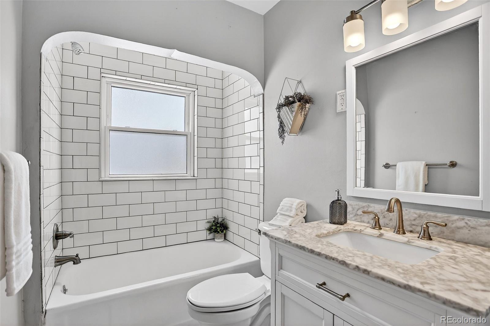 4185 Benton Street Denver, CO 80212 - Photo 15 of 40 a bathroom with a granite countertop sink toilet and bathtub