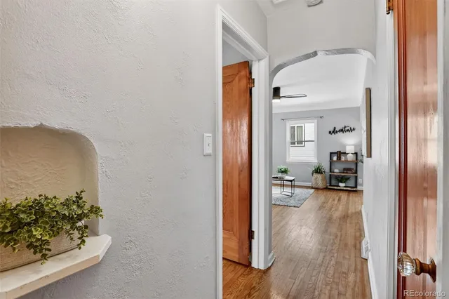 a view of a hallway with wooden floor and a living room