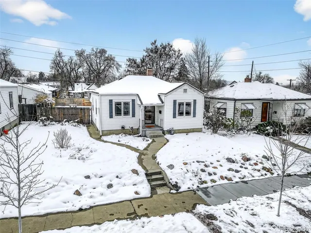 a view of a white house with a yard covered in snow