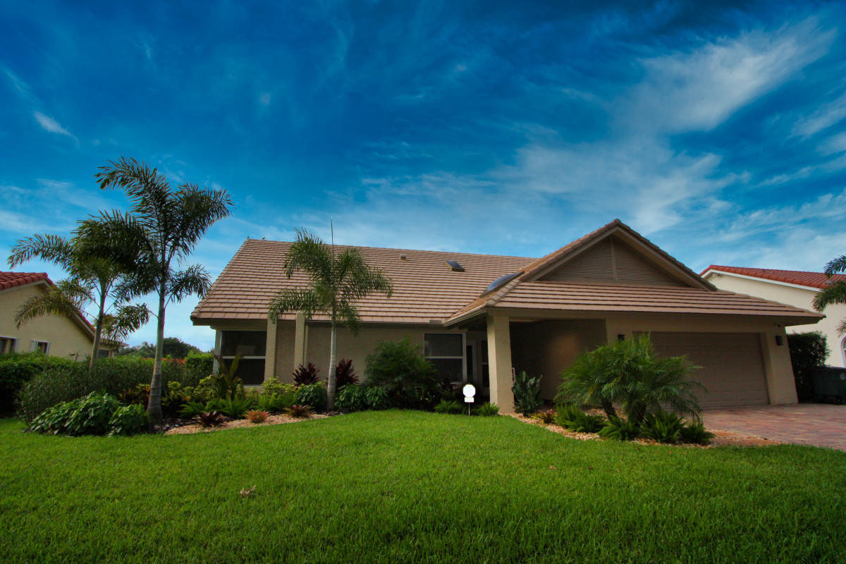 2541 Northwest 39th Street Boca Raton, FL 33434 - Photo 6 of 22 a front view of a house with a yard and garage