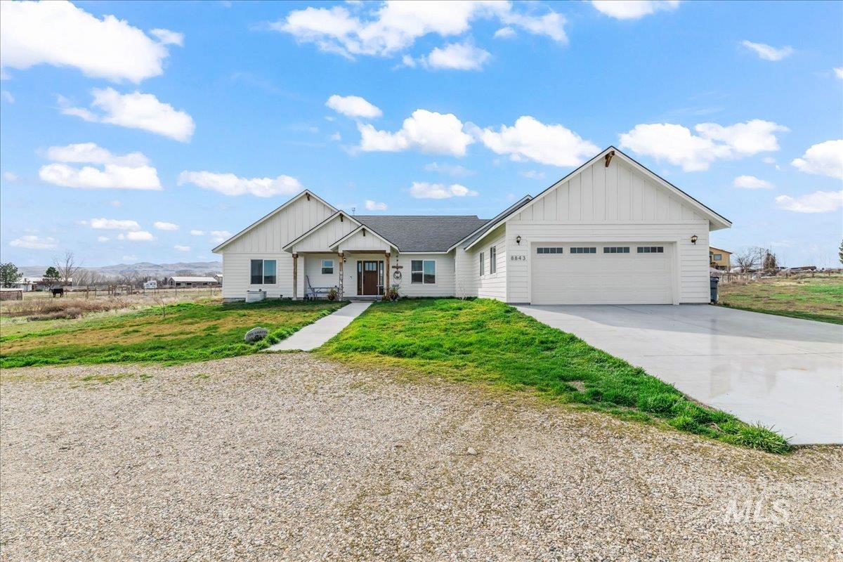 8843 Highway 78 Marsing, ID 83639 - Photo 1 of 48 View of front of home with board and batten siding, driveway, an attached garage, and a front lawn