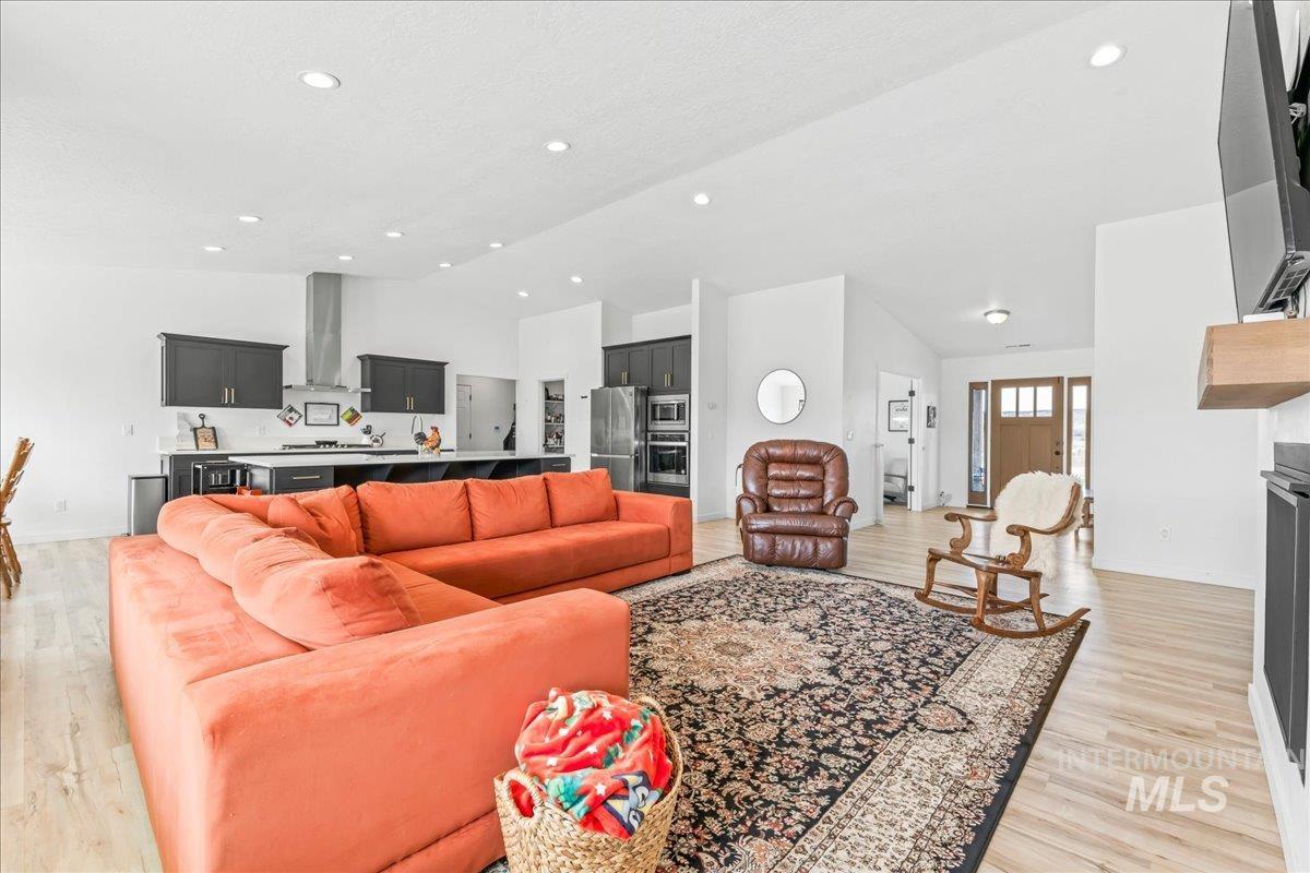 8843 Highway 78 Marsing, ID 83639 - Photo 11 of 48 Living room featuring light wood finished floors, a fireplace, vaulted ceiling, and recessed lighting