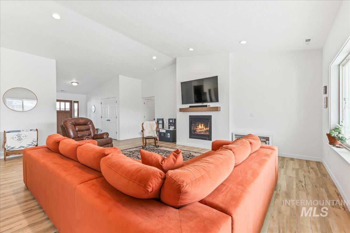 8843 Highway 78 Marsing, ID 83639 - Photo 12 of 48 Living area featuring a glass covered fireplace, light wood-type flooring, lofted ceiling, and recessed lighting